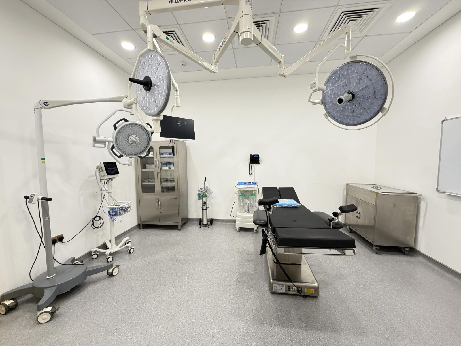 Modern hospital operating room equipped with surgical lights, operating table, and advanced medical equipment.