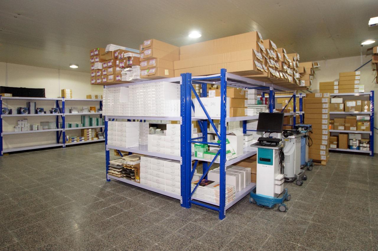 Medical supply warehouse with organized shelves containing hospital equipment, surgical supplies, and packaged inventory.